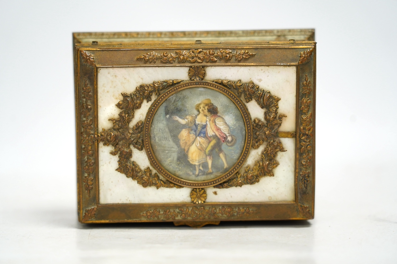 A French mother of pearl and gilt metal trinket box inset with a hand painted panel of two figures, 15cm wide. Condition - fair, feet present (one broken)